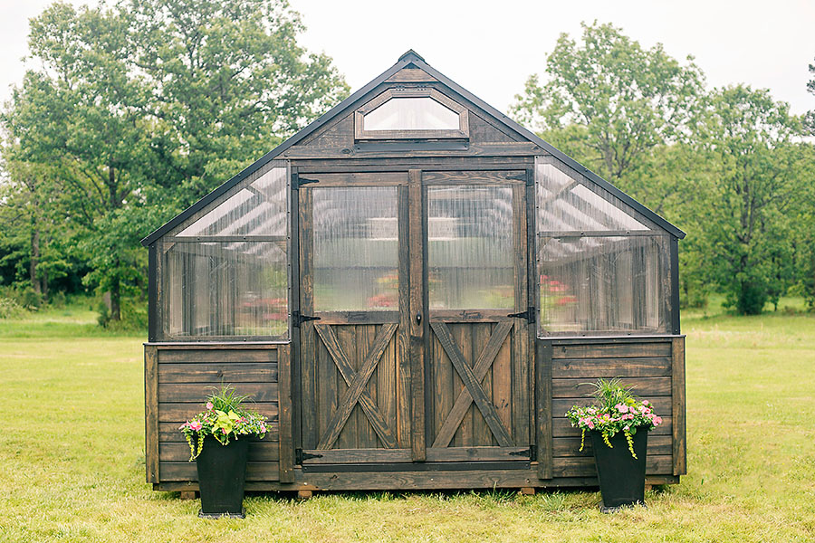 Front view of a 12x24 Yoderbilt Legacy Greenhouse with gray stain. Double doors are closed.