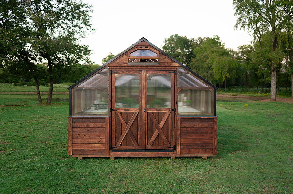 12x32 Yoderbilt Legacy Greenhouse exterior from the front with brown stain. The double doors closed.