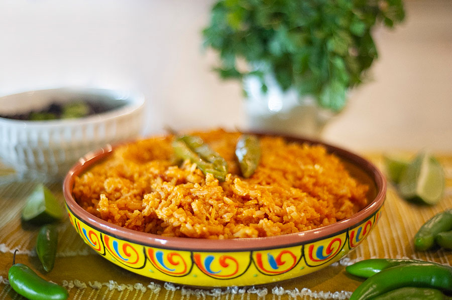 A large dish of Spanish rice with Serrano peppers on top.