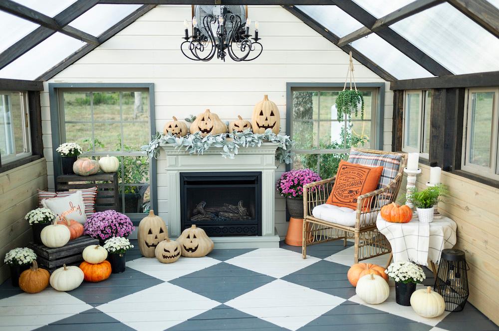 Interior of a Yoderbuilt Greenhouse decorated for Halloween with various pumpkins and jack-o-lanterns.