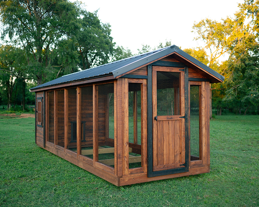 Exterior of a Yoderbilt chicken coup with single door and with brown stain and black trim.