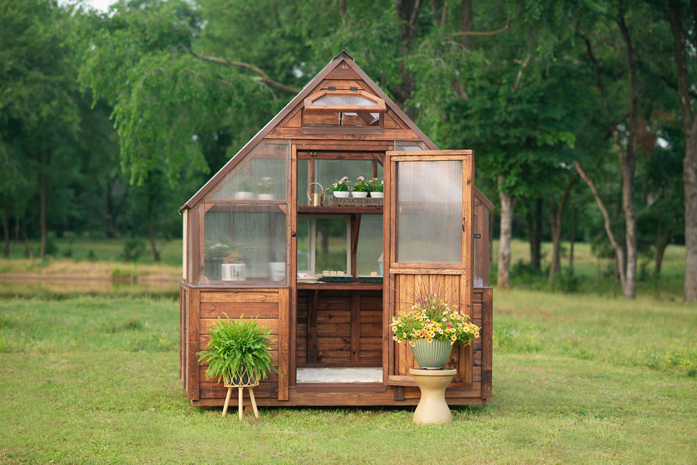 8x8 Yoderbilt Legacy Greenhouse with brown stain and brown metal trim - featuring an upper and lower built-in back shelf