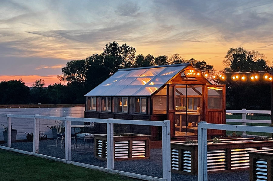 A Yoderbilt Greenhouse with a sunset in the background