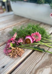 Variety of single flowers placed on top of a gardening table