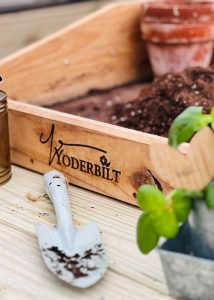 Yoderbilt gardening tools sitting on top of a gardening table.