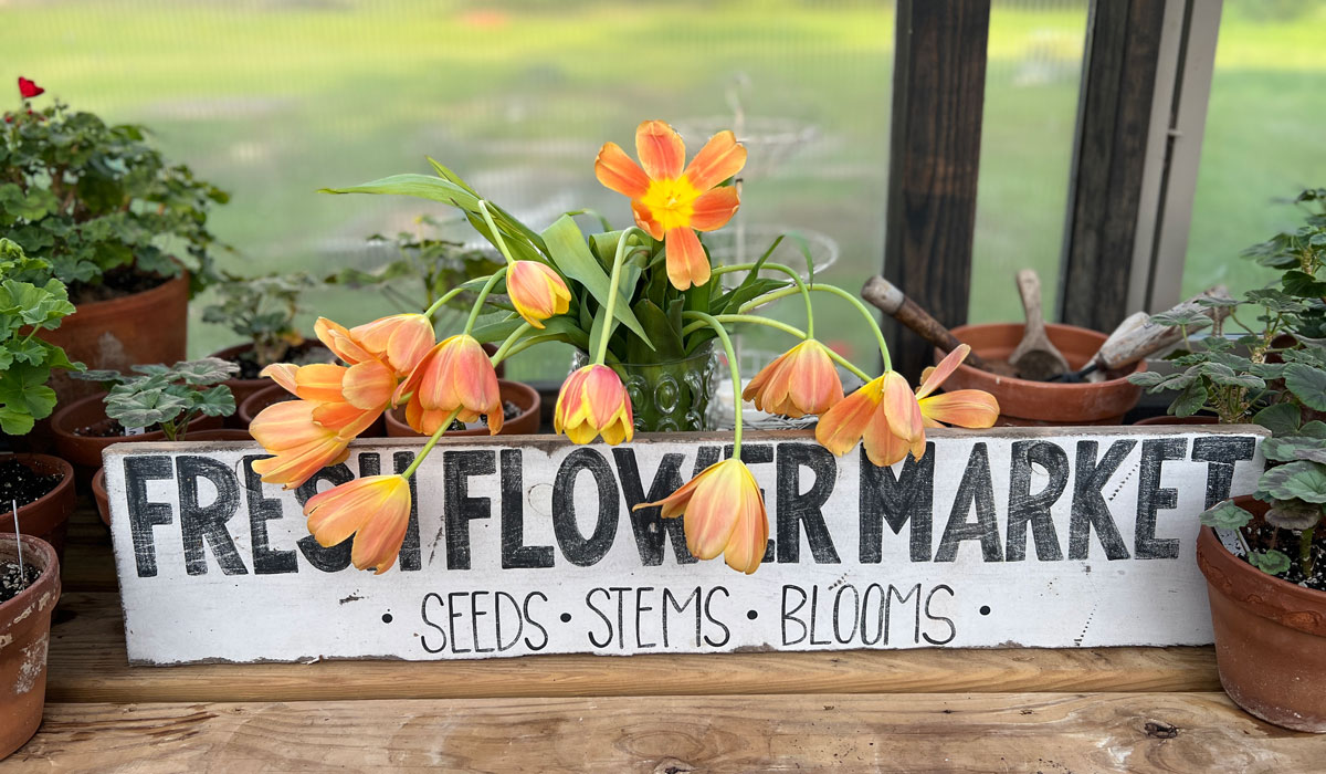 A "Fresh Flower Market" decorative sign inside of a Yoderbilt Greenhouse